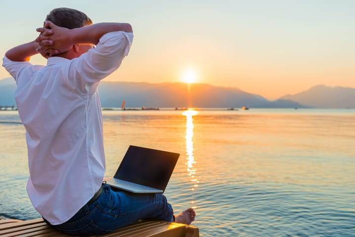 Recreational entrepreneur. Man with laptop in the morning on the beach working